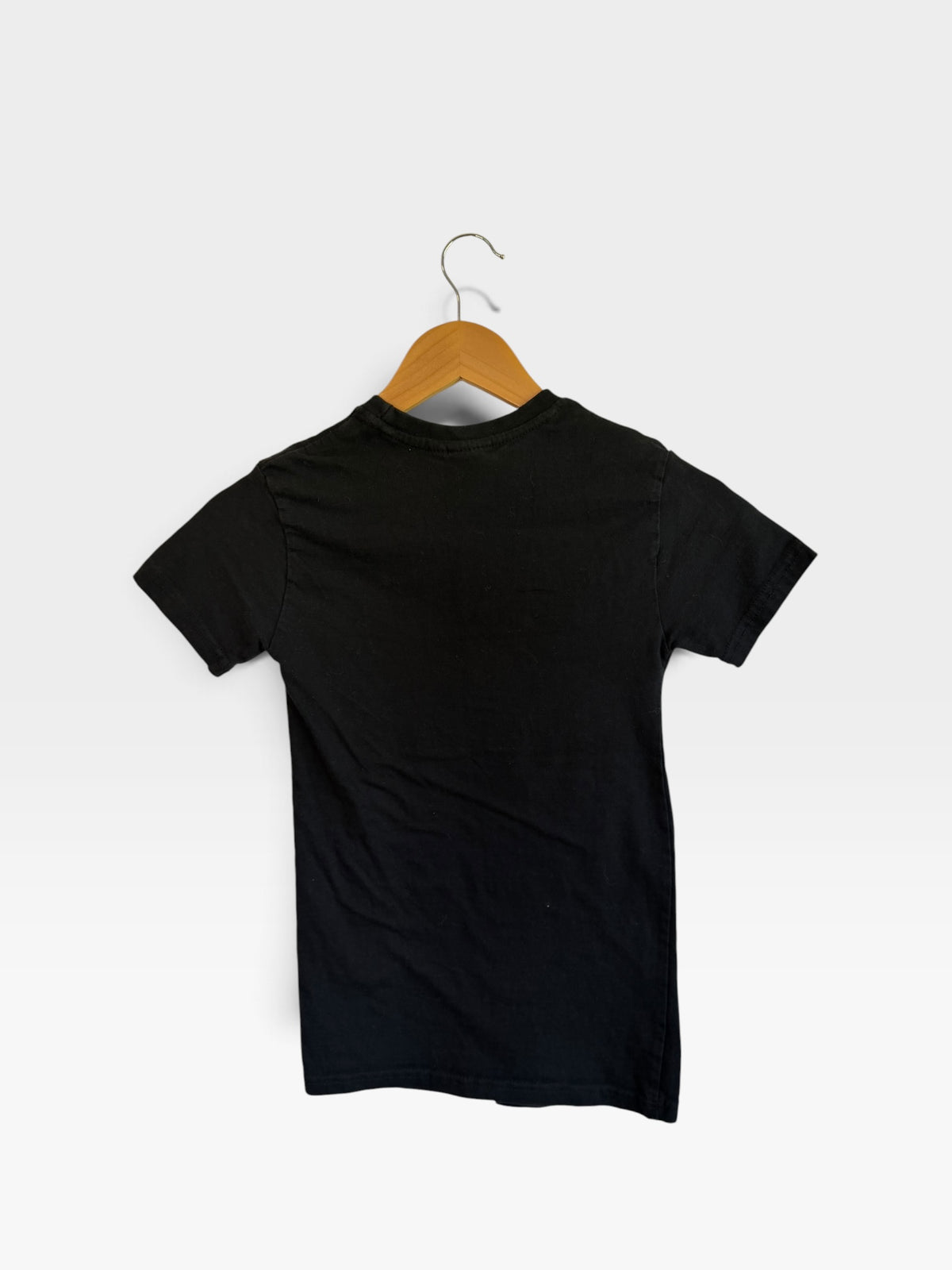 225 Threadz black short sleeve crewneck t-shirt hanging on a wooden hanger, back view