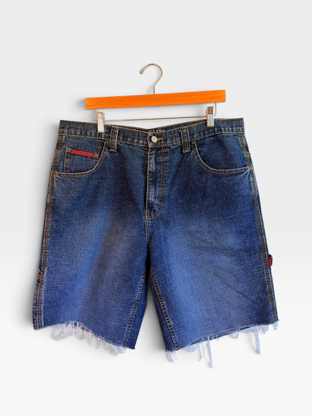 225 Threadz U.S. POLO ASSN. medium-wash denim carpenter shorts with a raw-edge hem and utility loop on a hanger.