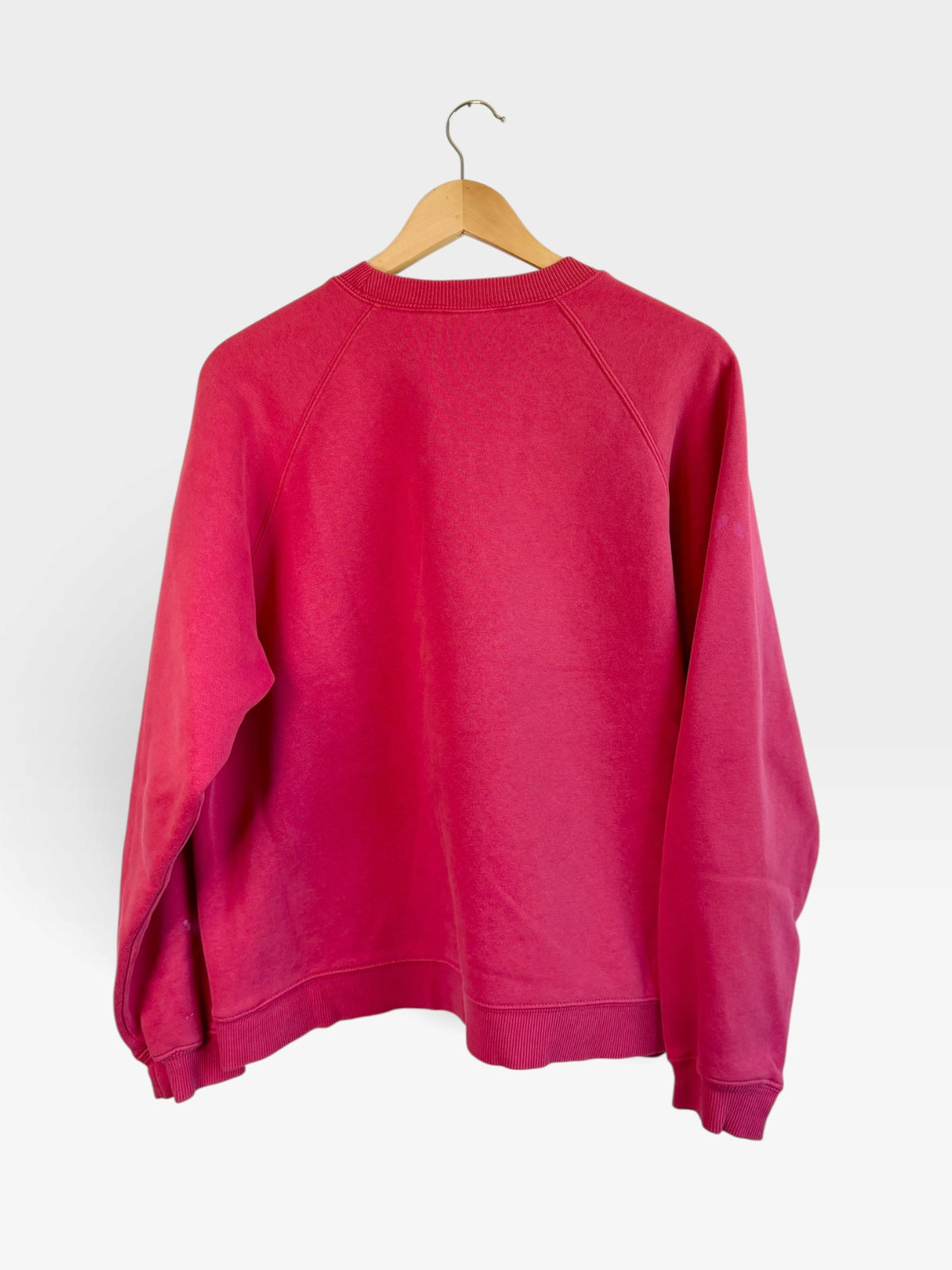 225 Threadz vintage pink adidas crewneck sweatshirt with raglan sleeves and ribbed cuffs hanging on a wooden hanger