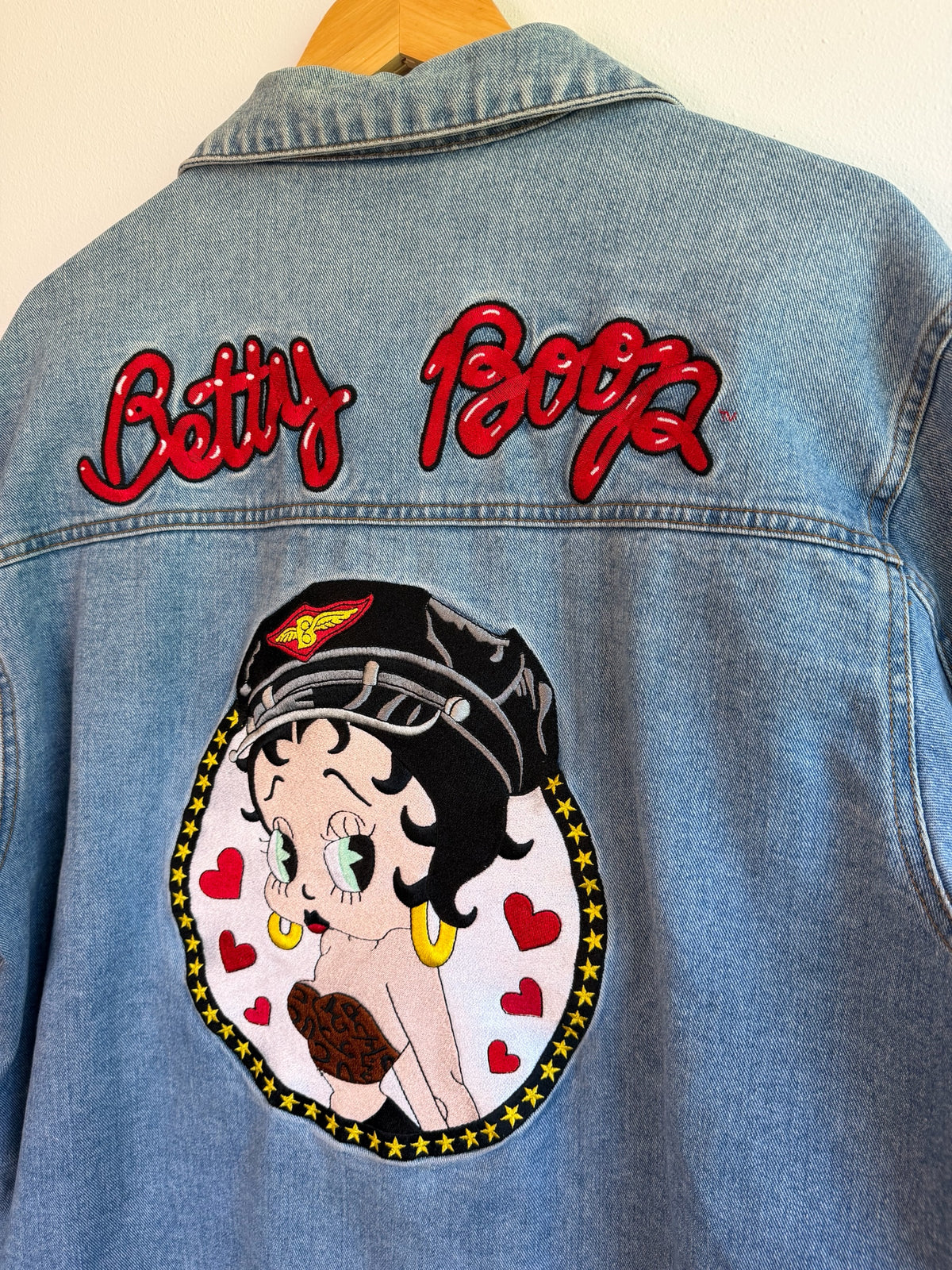 225 Threadz light-wash denim jacket featuring a large embroidered Betty Boop graphic on the back with red lettering.