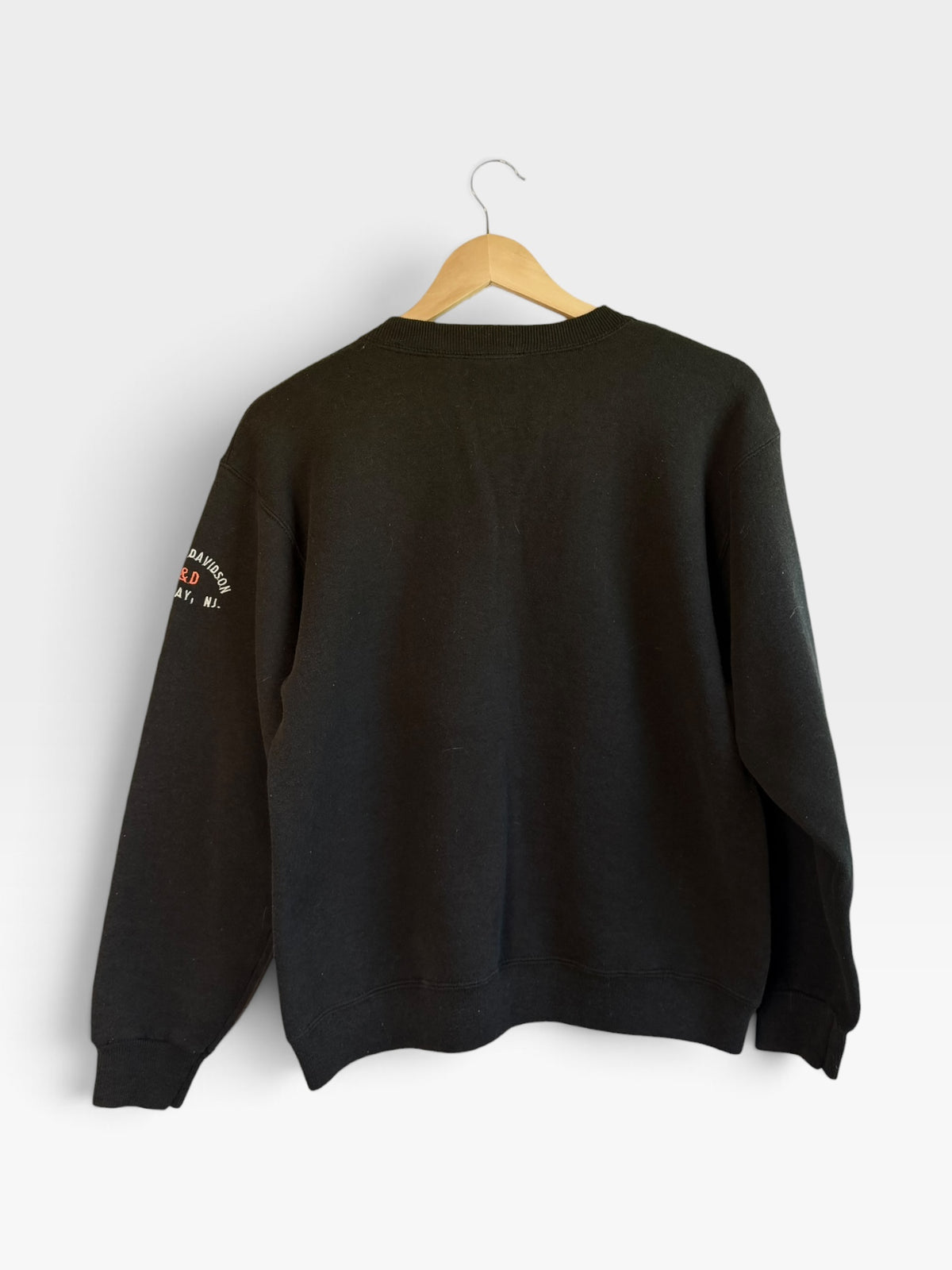 225 Threadz black Harley-Davidson crewneck sweatshirt with sleeve embroidery hanging on a wooden hanger