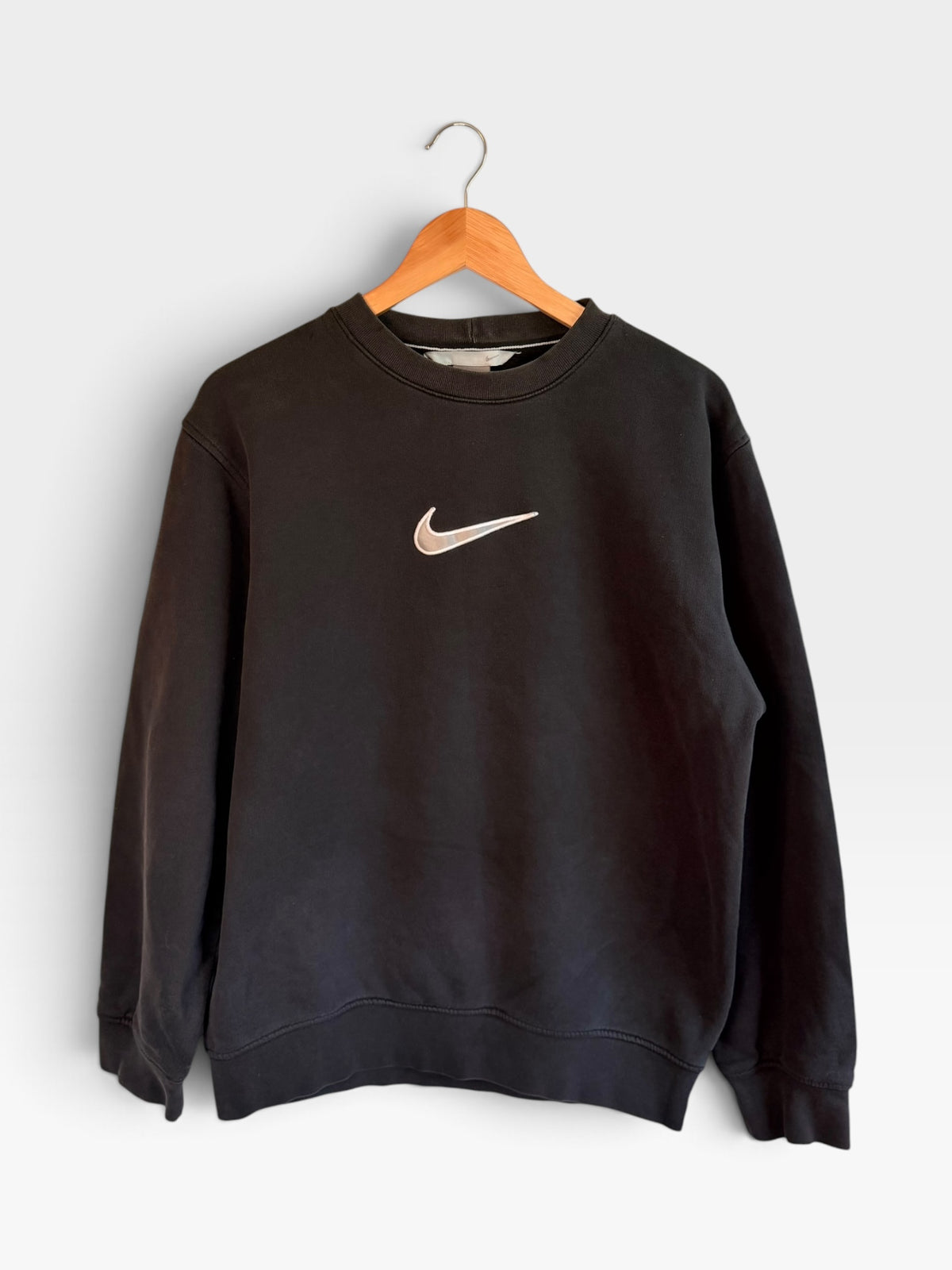 225 Threadz black Nike crewneck sweatshirt with a white embroidered Swoosh logo on the chest hanging on a hanger