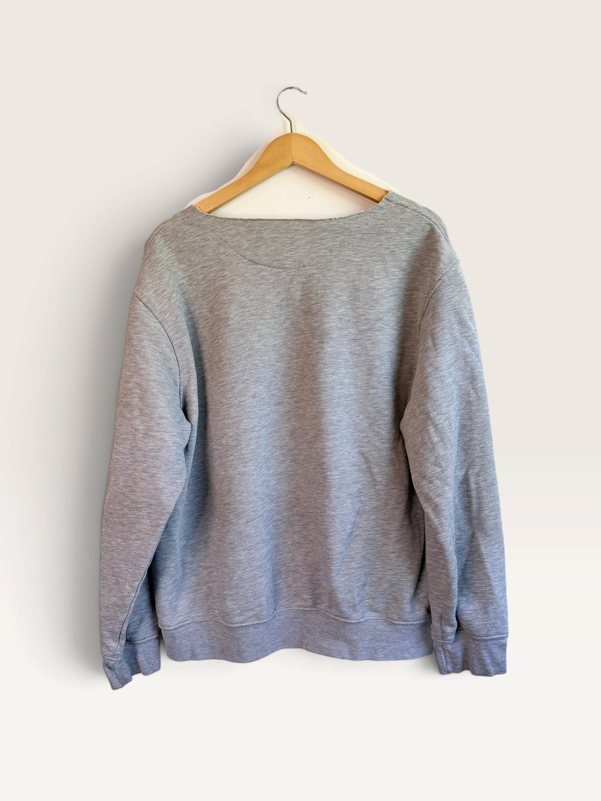 225 Threadz grey Nike long sleeve crewneck pullover sweatshirt hanging on a wooden hanger against a plain wall