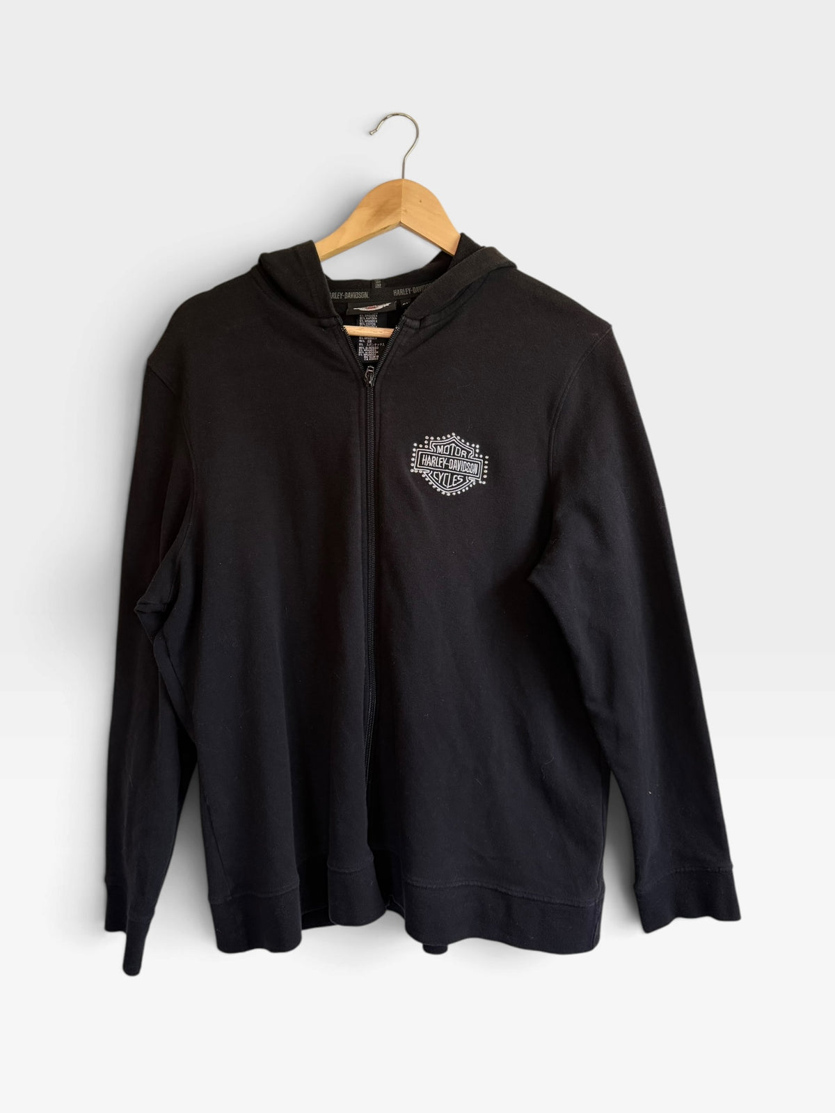 225 Threadz black Harley-Davidson full-zip hoodie with a white chest logo, hanging on a wooden hanger.