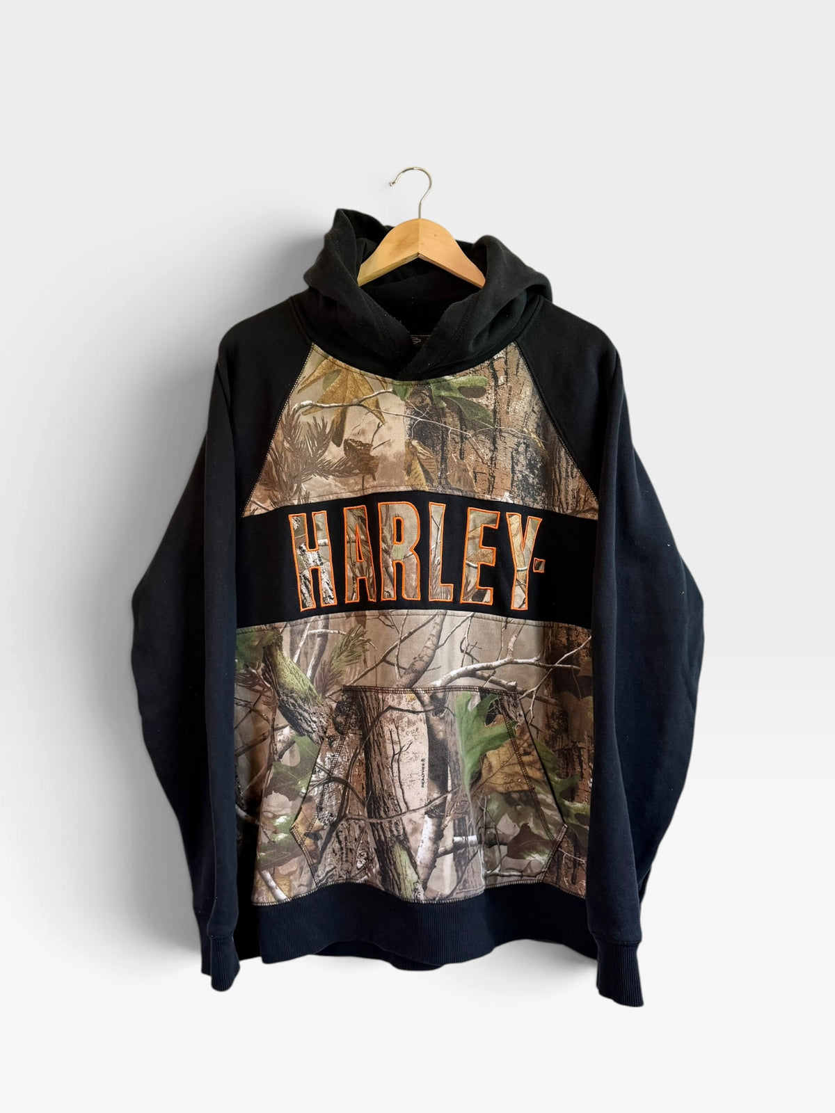 225 Threadz Harley-Davidson pullover hoodie featuring black sleeves and a woodland camouflage print with orange text.