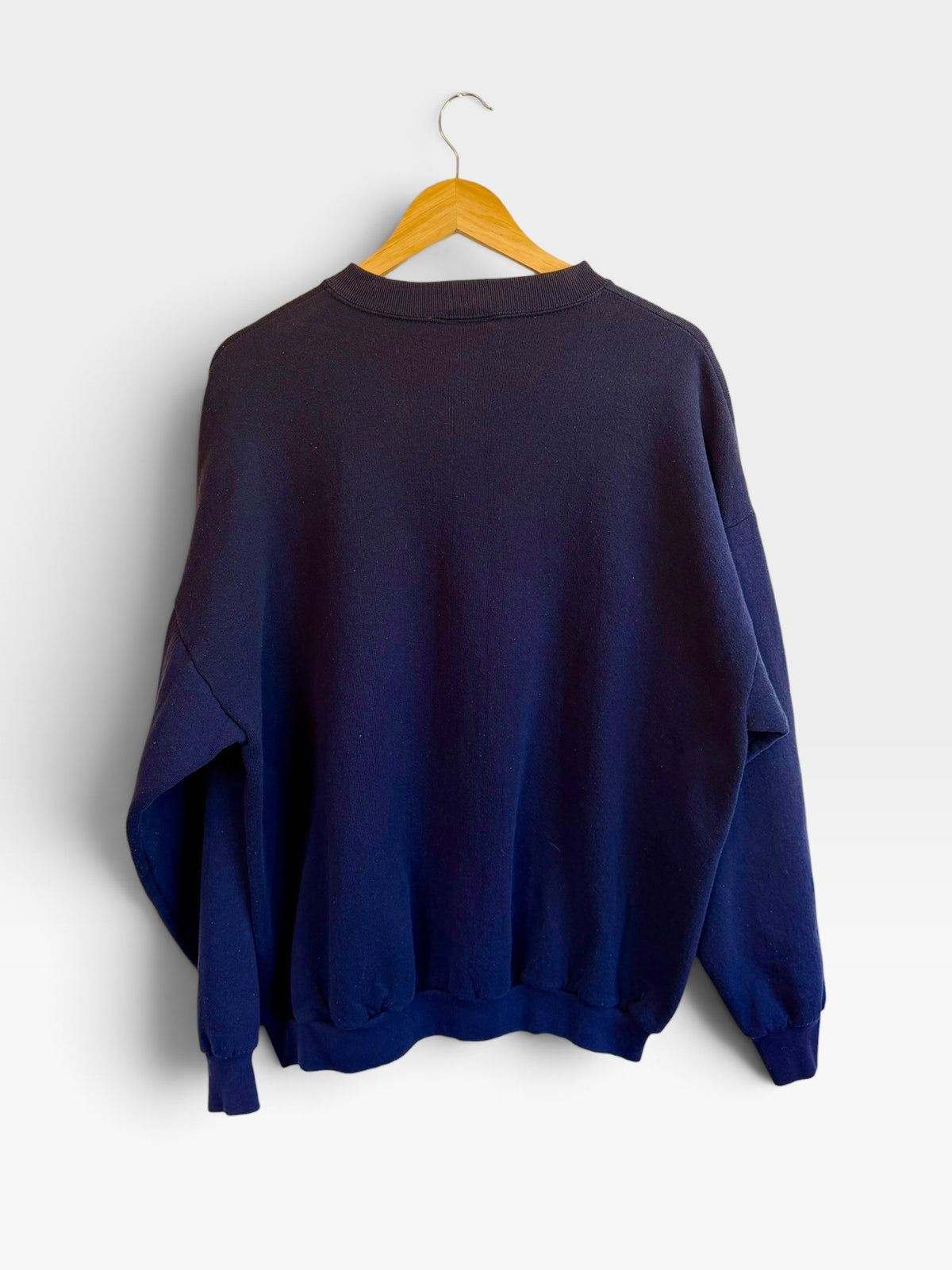 Back view of a 225 Threadz navy blue cotton-blend crewneck sweatshirt hanging on a wooden hanger.