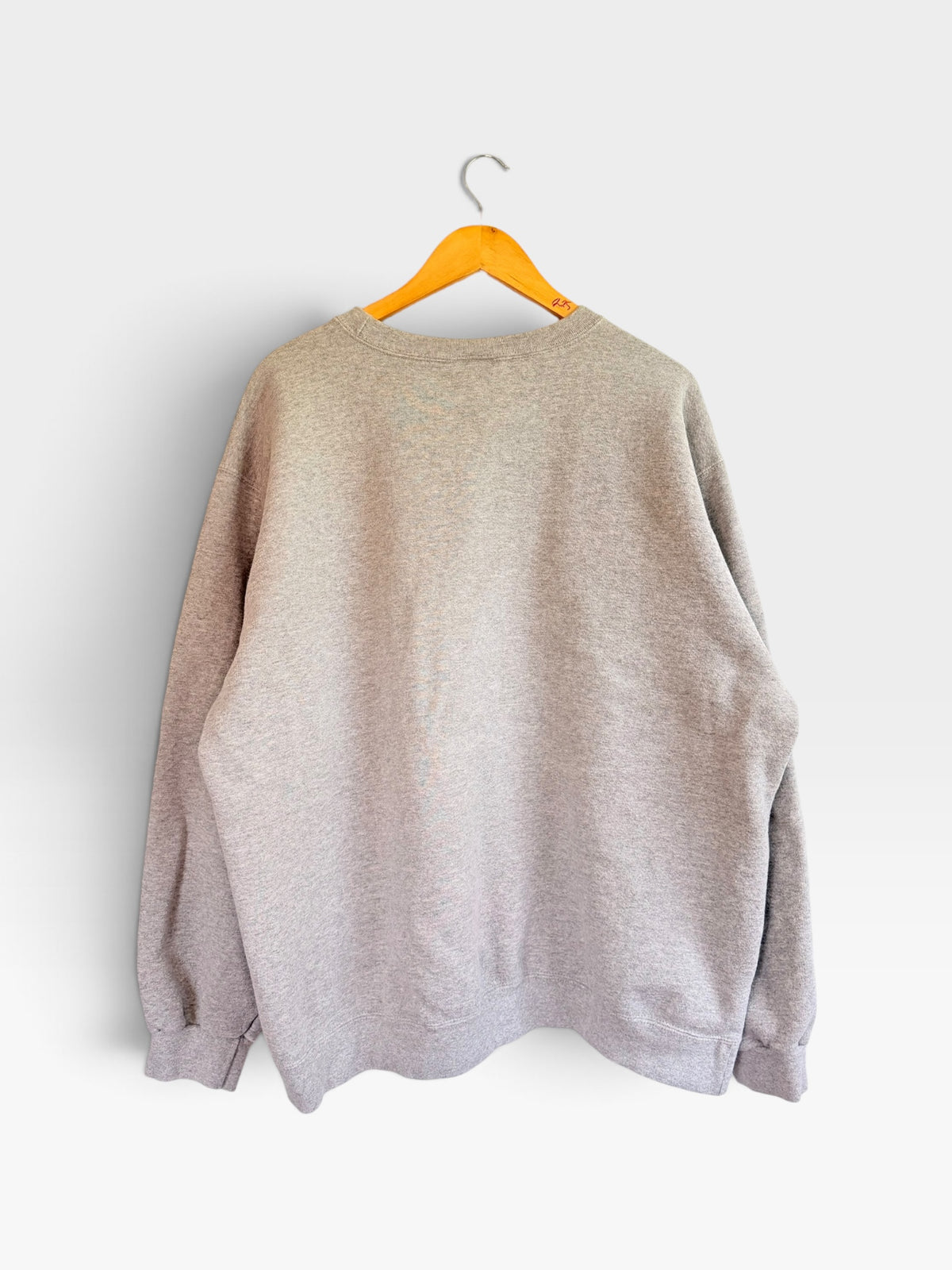 225 Threadz heather grey Nike crewneck pullover sweatshirt hanging on a wooden hanger against a white wall.