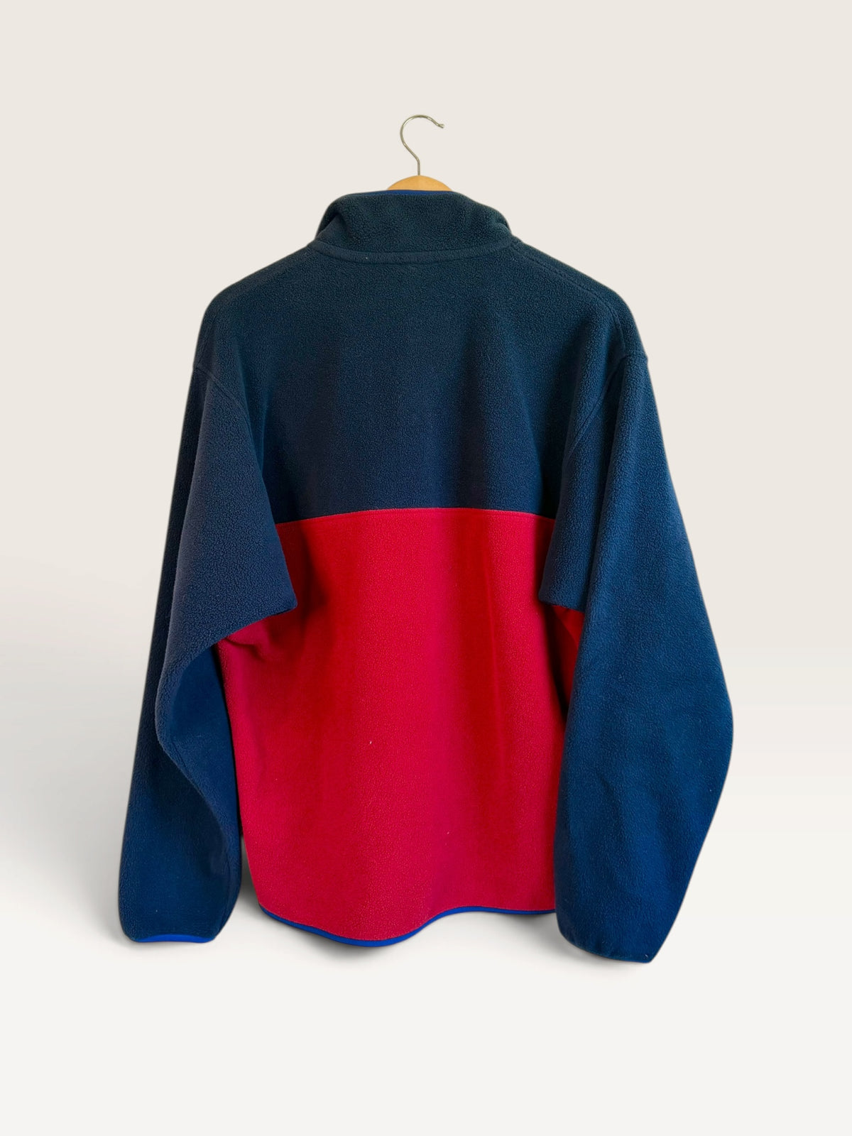 225 Threadz Patagonia navy and red color-blocked fleece pullover jacket seen from the back on a hanger