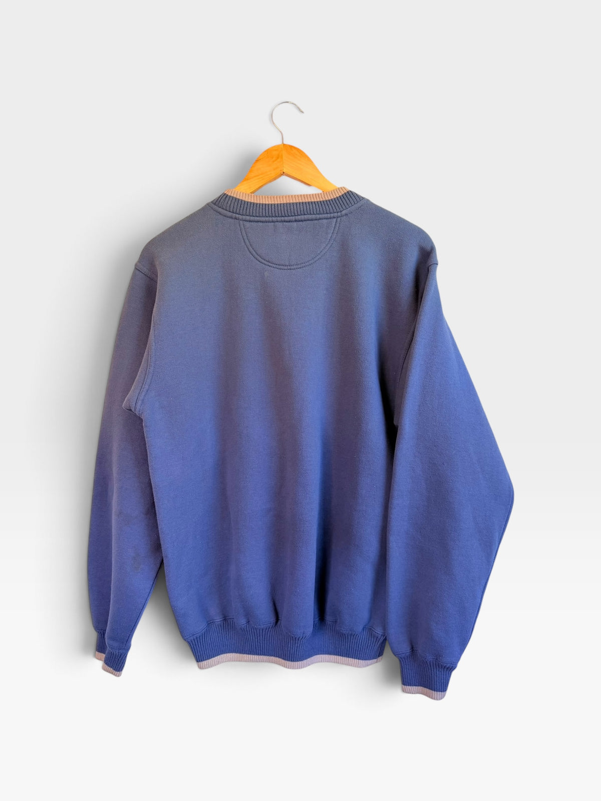 Back view of a 225 Threadz periwinkle blue crewneck sweatshirt with layered ribbed collar and cuffs on a hanger
