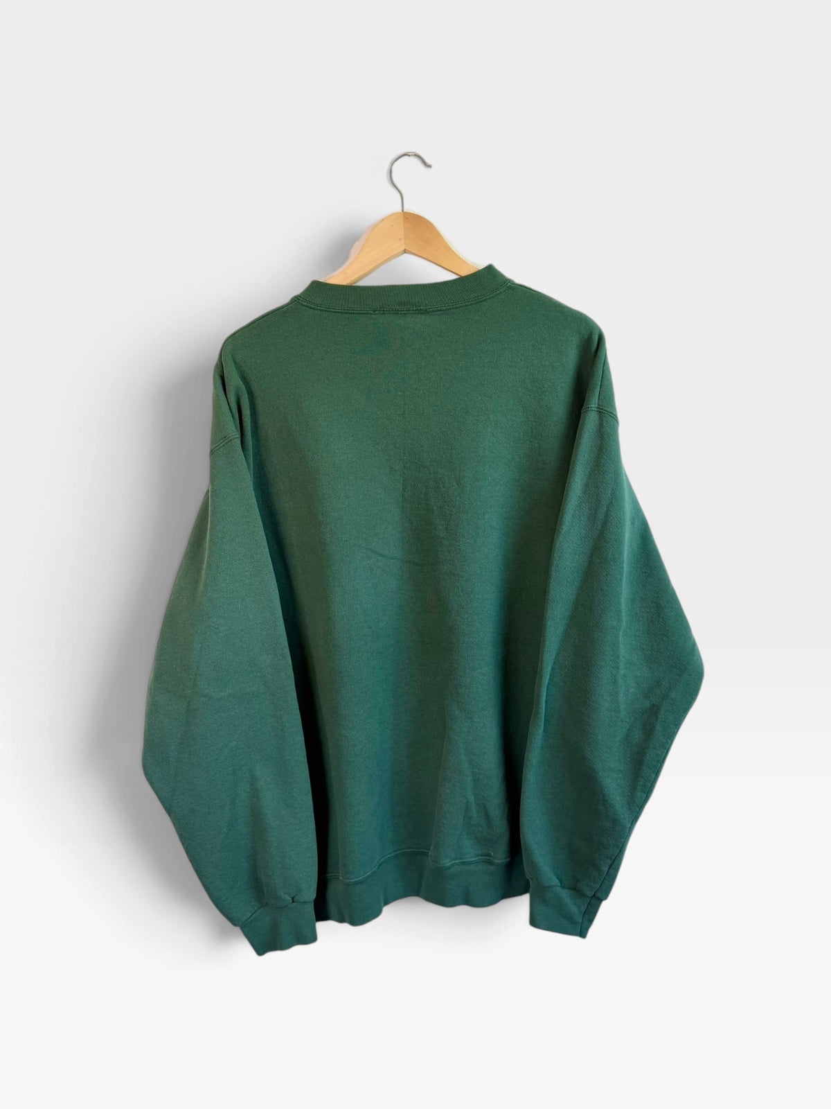 225 Threadz Polo Ralph Lauren deep green crewneck pullover sweatshirt hanging on a wooden hanger against a white wall.