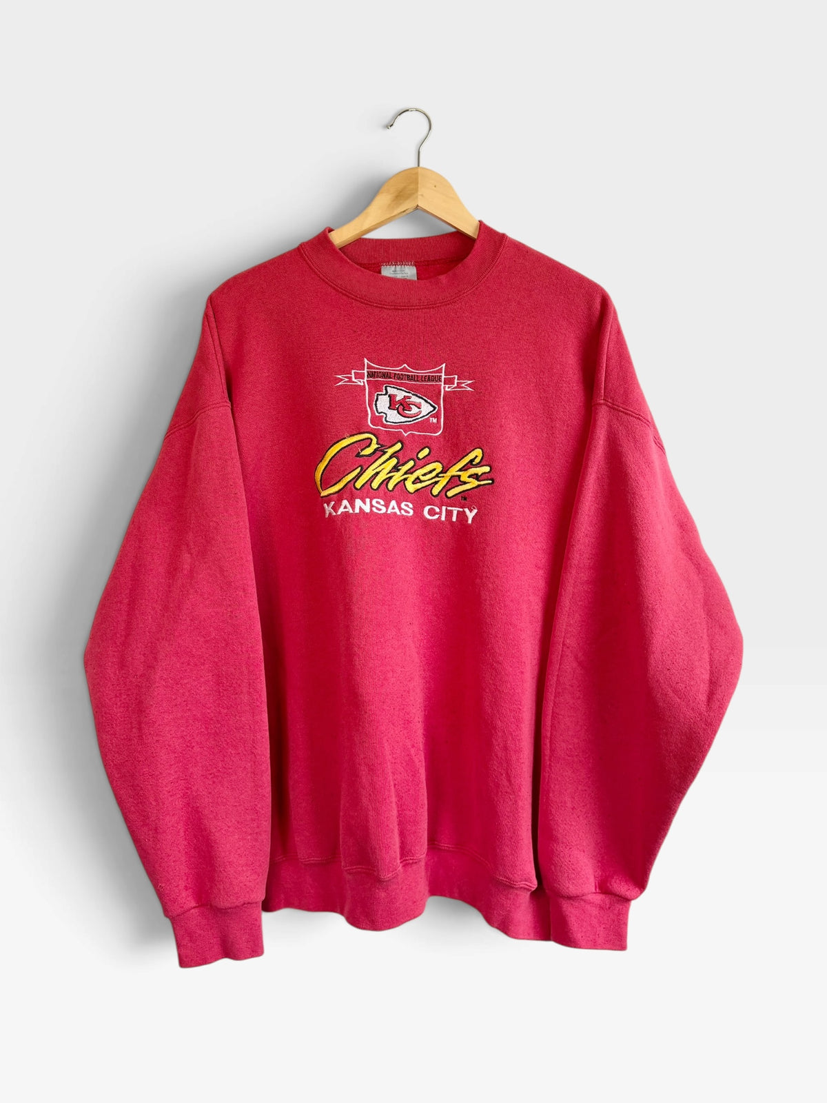 225 Threadz red vintage-style Kansas City Chiefs crewneck sweatshirt with embroidered team logo on a wooden hanger