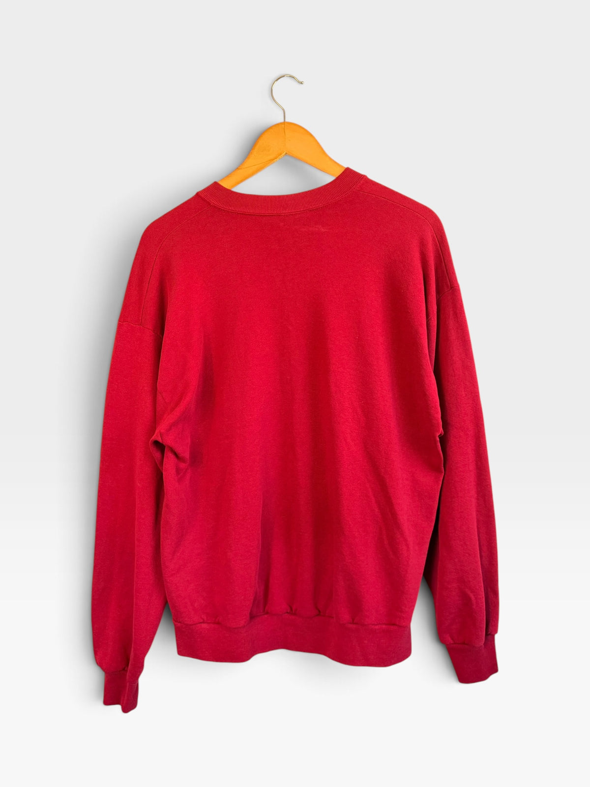 225 Threadz vintage style red crewneck sweatshirt hanging on a wooden hanger against a plain background