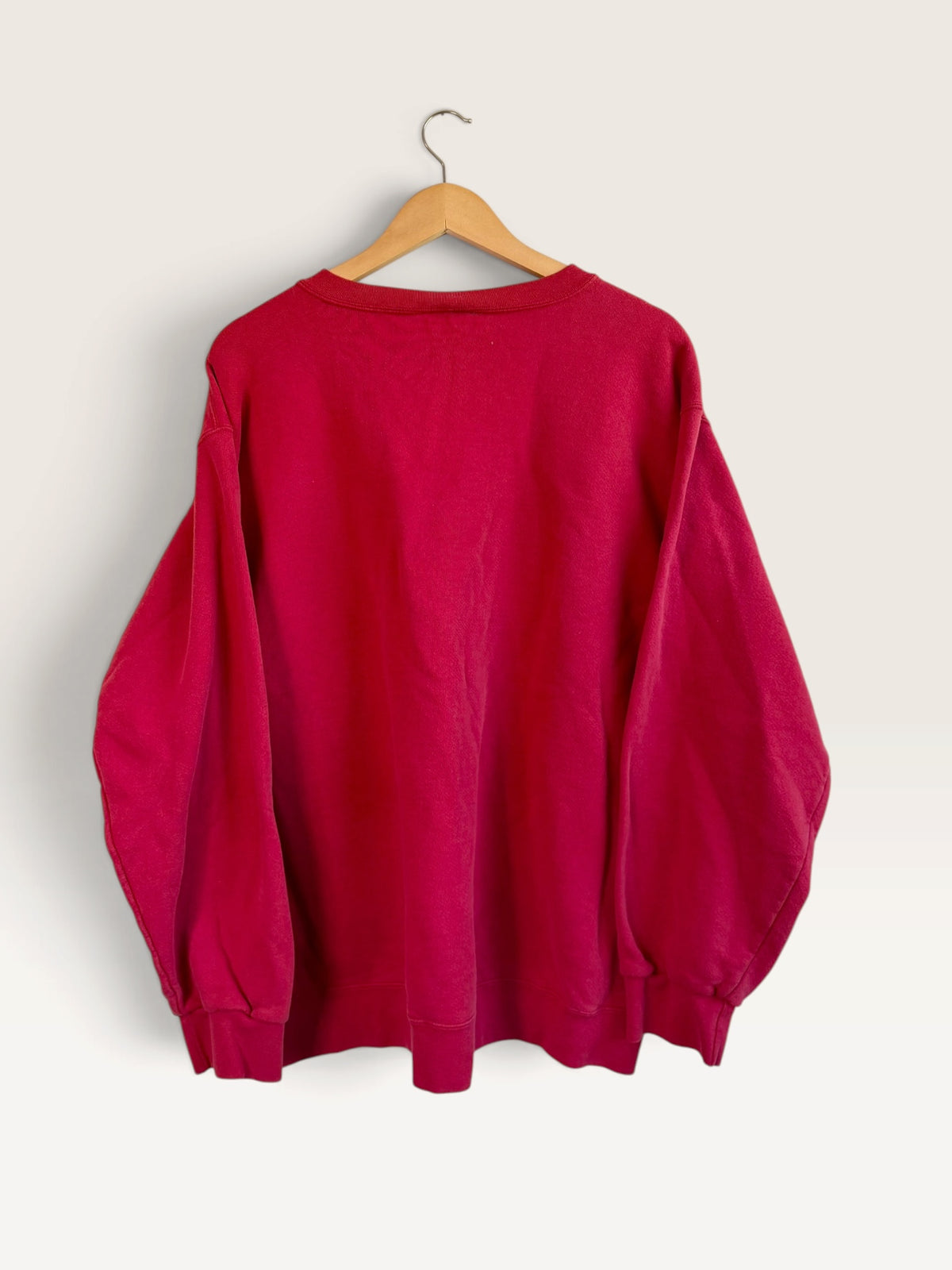 225 Threadz red Nike crewneck pullover sweatshirt with ribbed cuffs and hem hanging on a wooden hanger