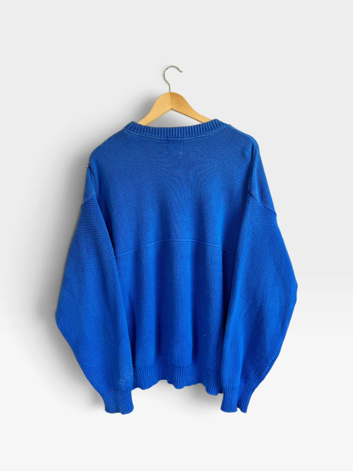 225 Threadz vintage royal blue crewneck knit sweater with textured pattern and ribbed hem hanging on a wooden hanger