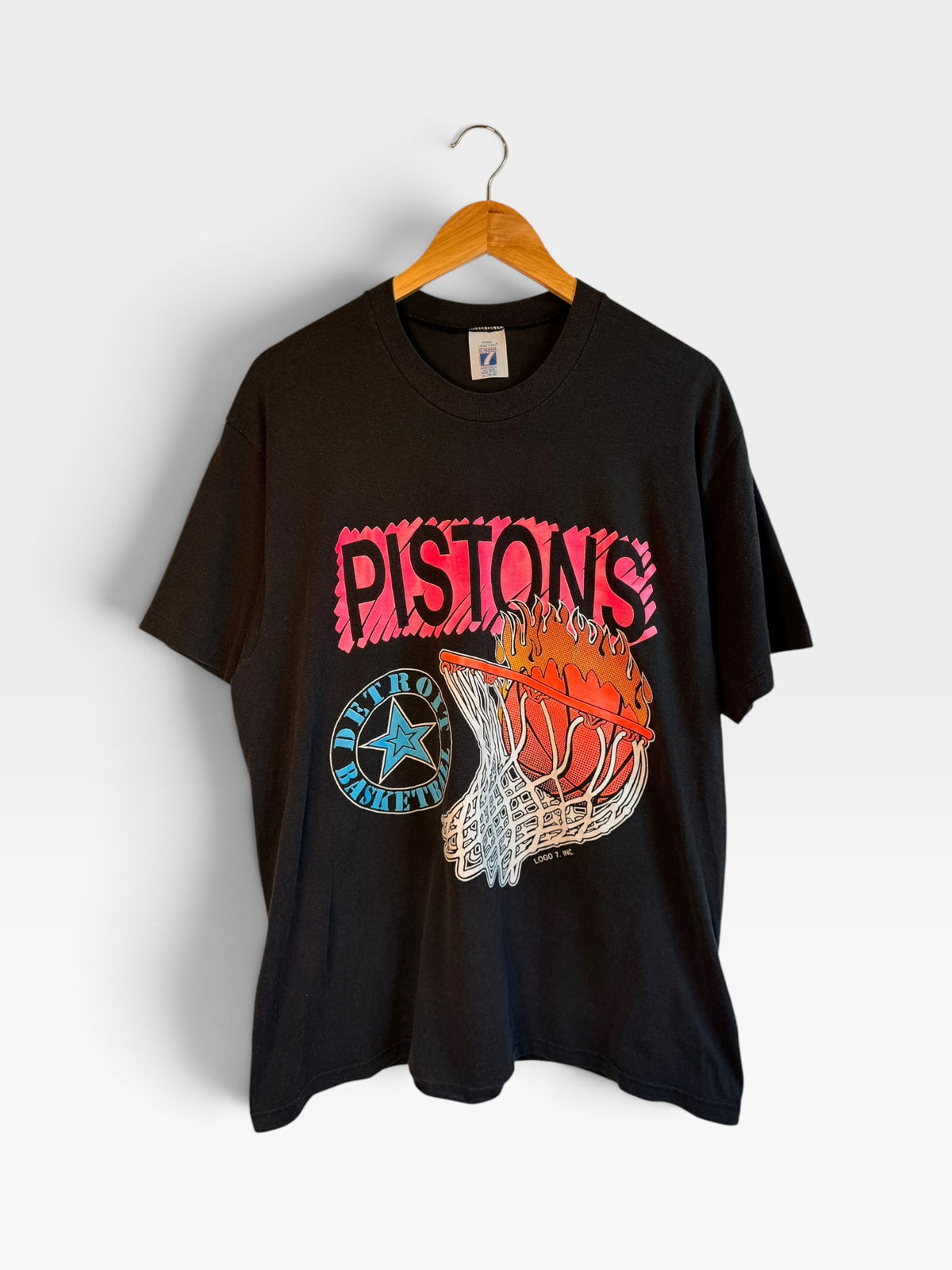 225 Threadz vintage black Detroit Pistons graphic t-shirt with a flaming basketball design on a wooden hanger.