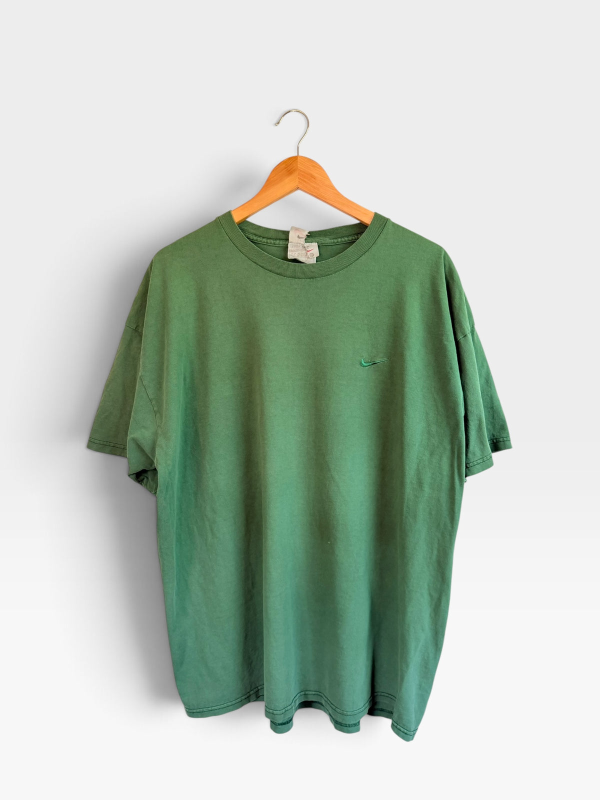225 Threadz vintage forest green Nike crewneck t-shirt with a tonal embroidered Swoosh logo on a wooden hanger.