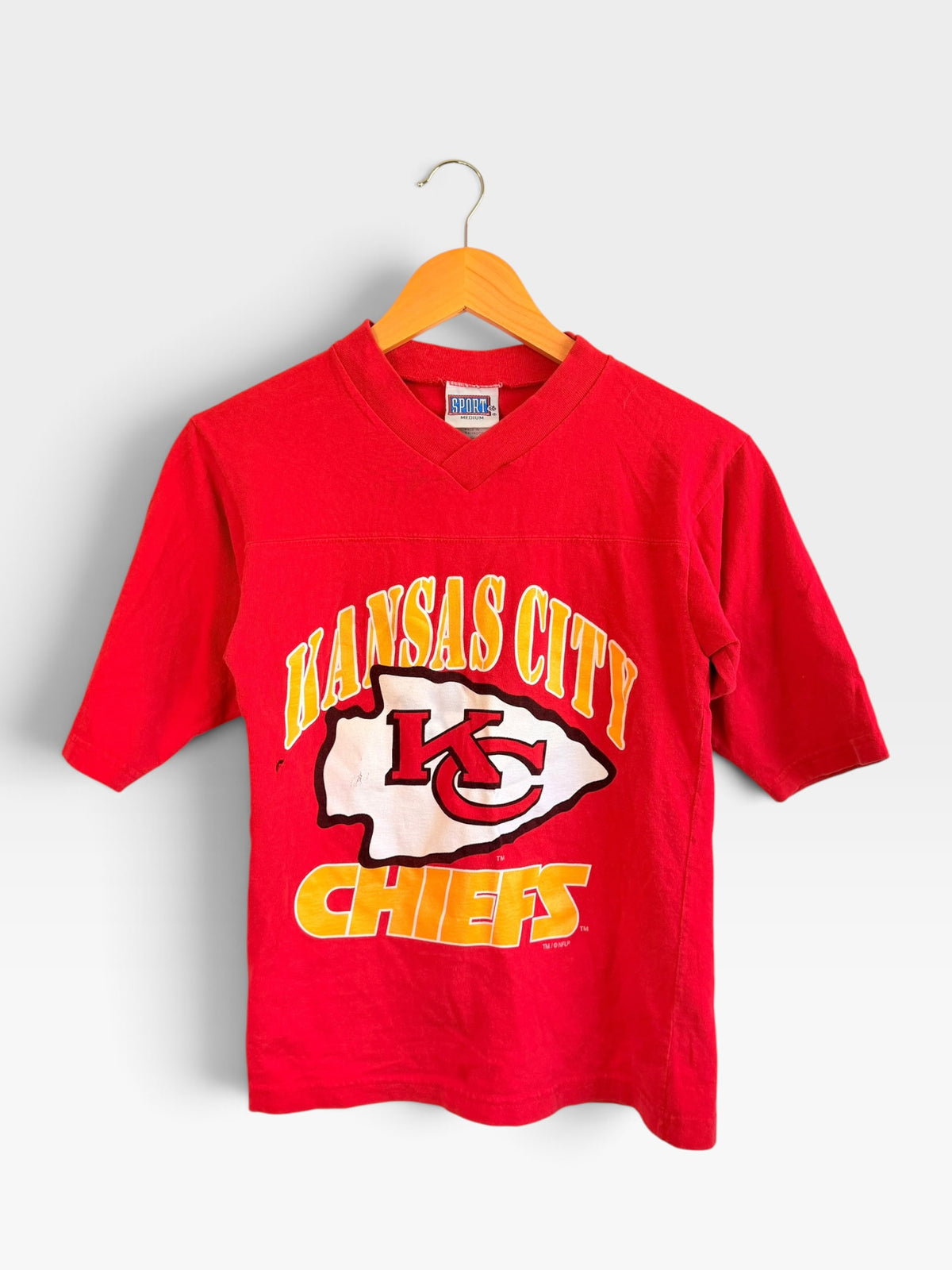 225 Threadz vintage red Kansas City Chiefs v-neck football t-shirt with screen-printed team logo on a wooden hanger