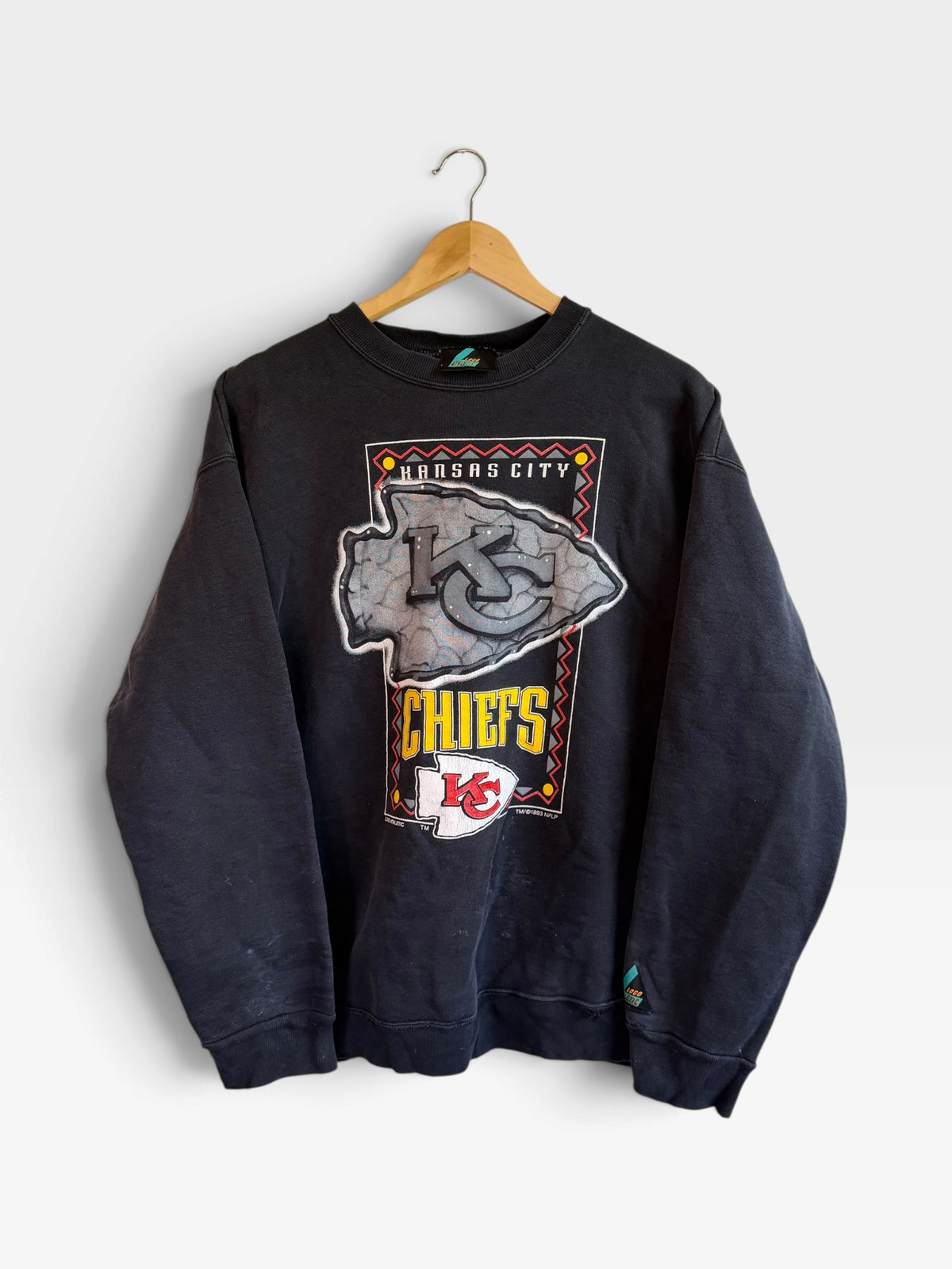 225 Threadz vintage black Kansas City Chiefs crewneck sweatshirt with retro arrowhead graphic on a wooden hanger.
