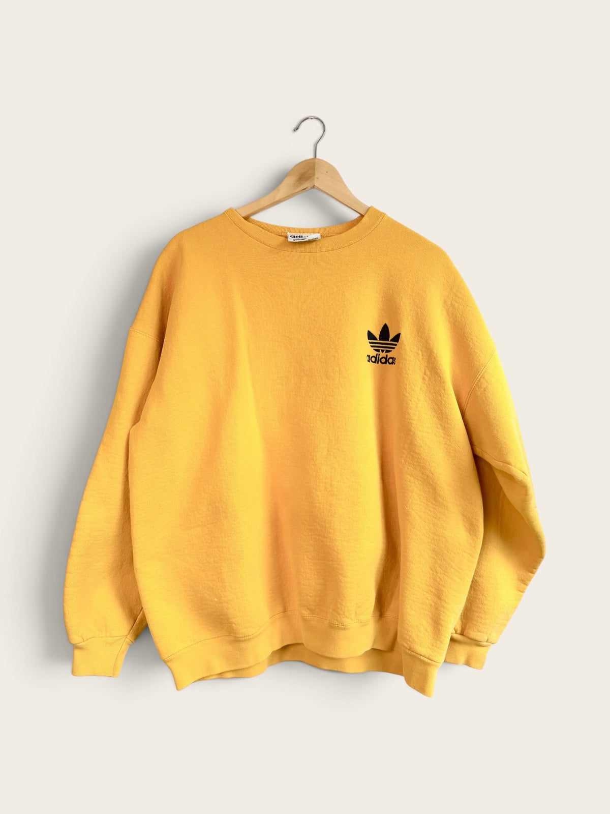 225 Threadz vintage yellow Adidas crewneck sweatshirt with black embroidered Trefoil logo on a wooden hanger
