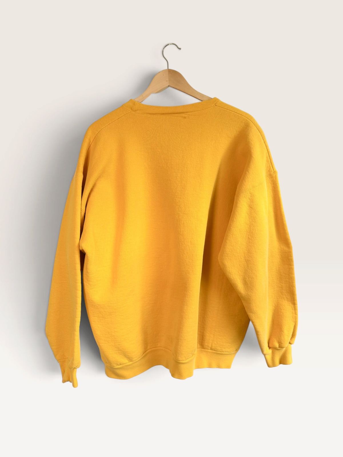 Back view of a vibrant yellow 225 Threadz vintage adidas crewneck sweatshirt hanging on a wooden hanger.